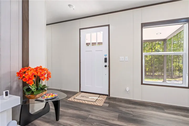 An inviting entryway features a classic paneled front door and clean-lined wood flooring.