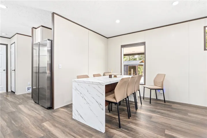 An open dining area features smooth wood-look flooring and clean lines throughout.