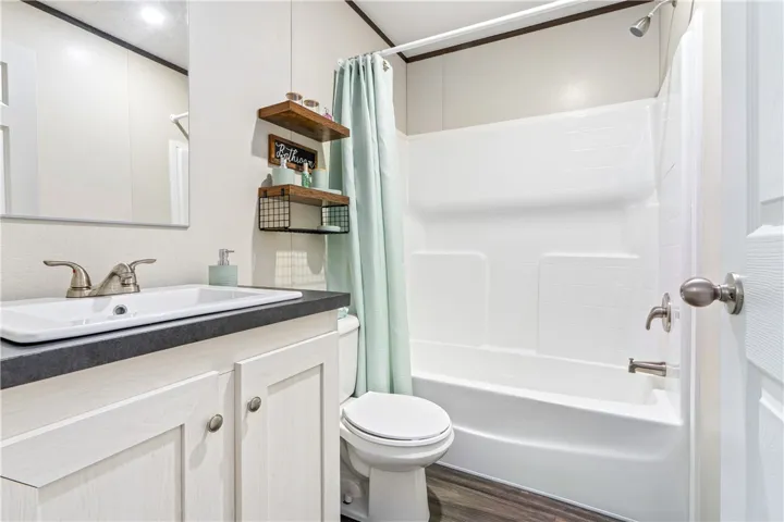 Clean lines and a functional layout define this well-appointed bathroom with durable wood-look flooring.