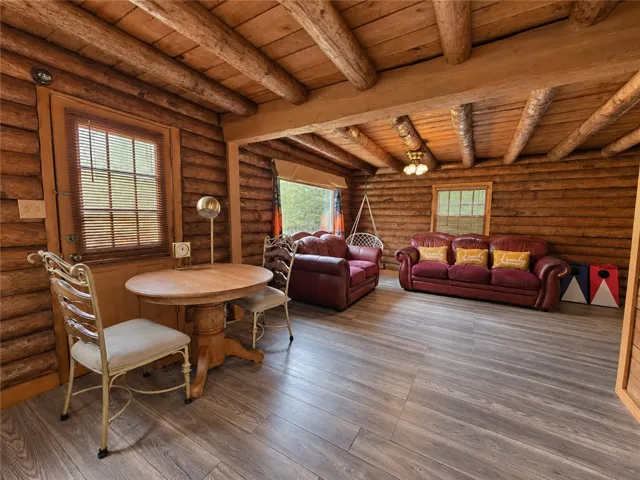 Natural wood textures and exposed logs create a warm, rustic atmosphere throughout this living area.