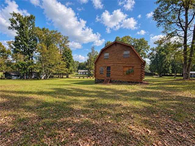Rustic log construction defines this charming retreat nestled on a spacious grassy clearing.