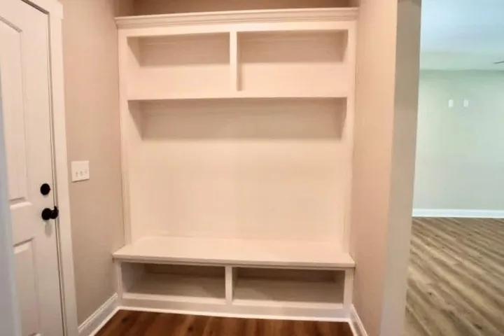A custom built-in bench with shelving offers convenient organization directly inside the entryway.