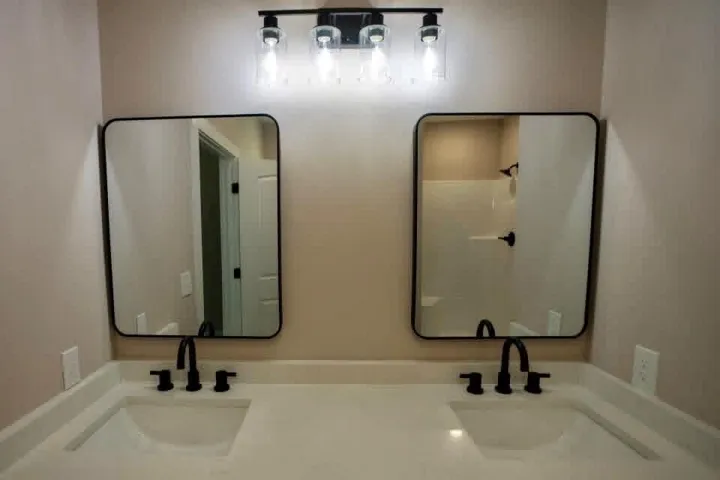 A refined dual vanity area showcases sleek black fixtures alongside clean minimalist mirrors.