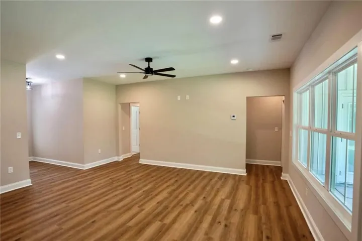 Rich wood-look flooring and recessed lighting define this versatile, open living area.