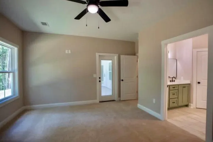 Plush carpeting and generous windows anchor this peaceful retreat with an attached bath.