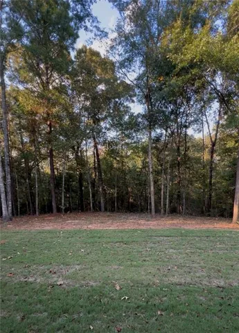 Mature trees frame a peaceful grassy lawn at the edge of the property.
