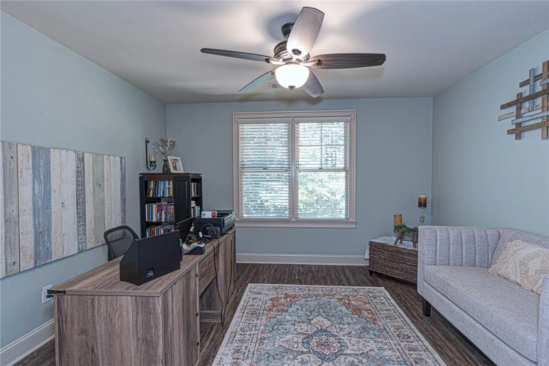 A spacious home workspace features durable wood-look flooring and a large double window.