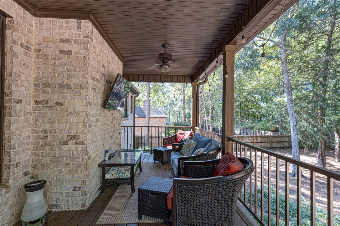 Rich wood plank ceilings and brick accents frame this serene elevated back porch.