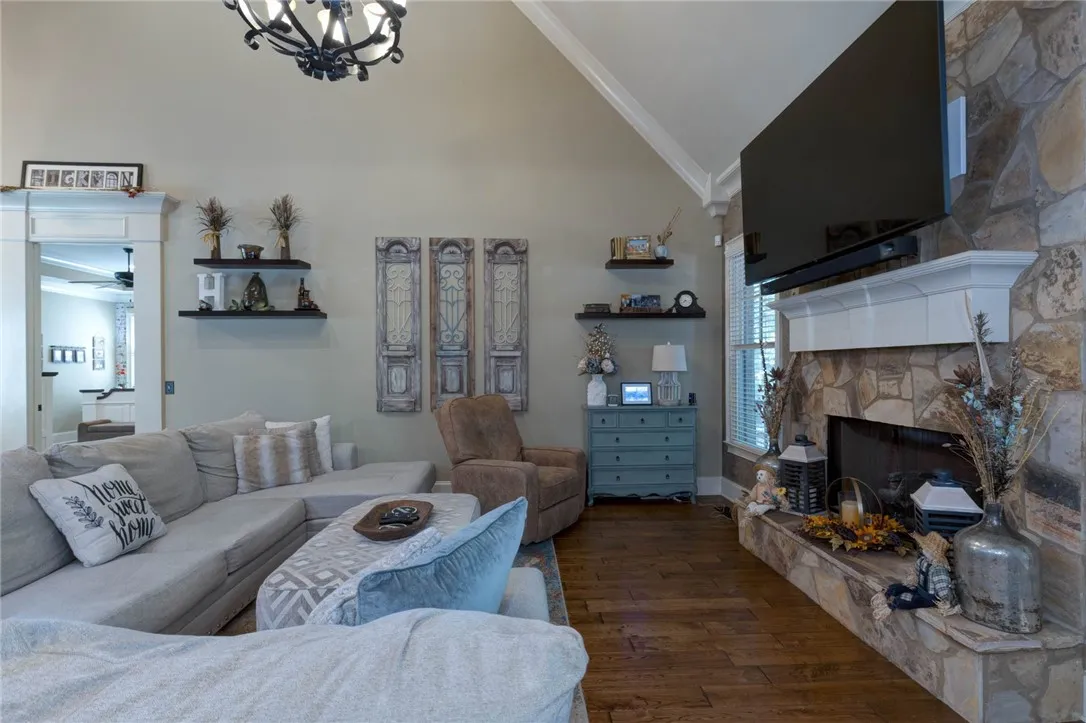 A stone fireplace anchors the living space under vaulted ceilings and handsome hardwood flooring.