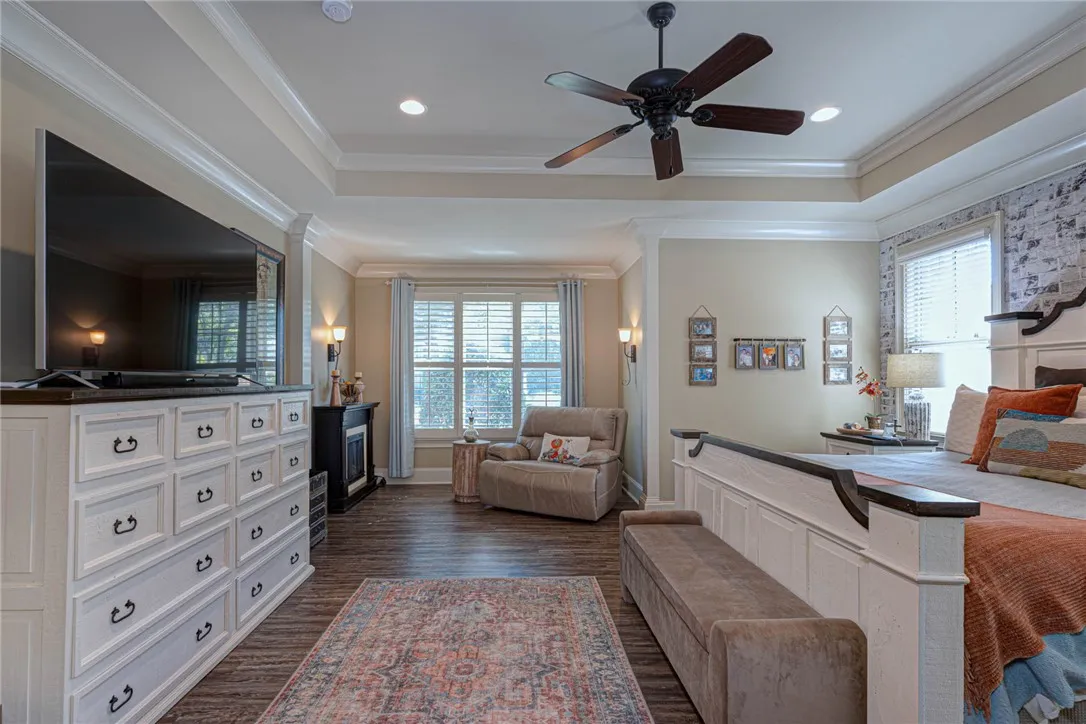 Elegant tray ceilings and warm wood floors anchor this comfortable master bedroom suite.