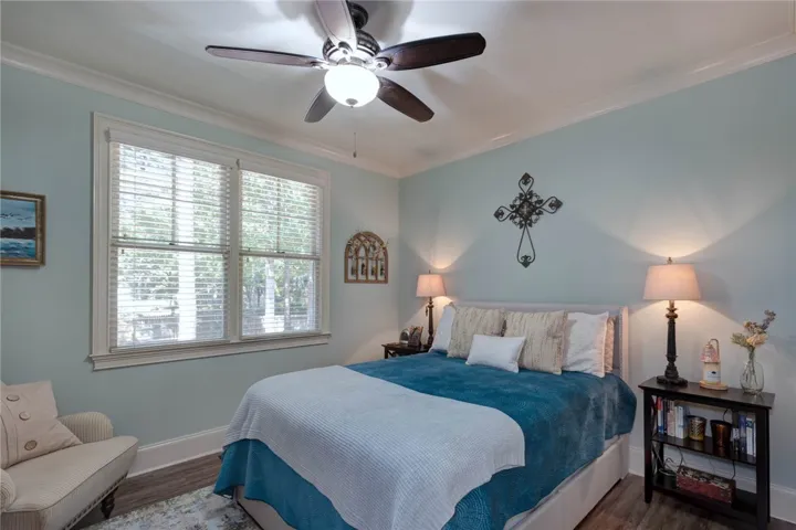Double windows fill this serene space with natural light highlighting clean crown molding.