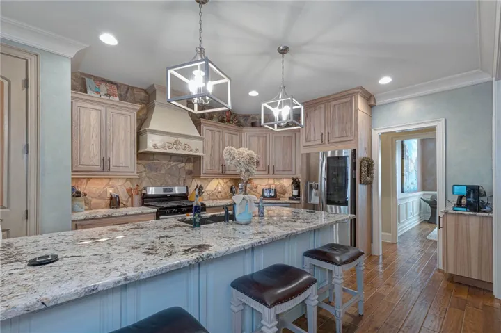 Gleaming granite countertops pair beautifully with custom cabinetry and rich hardwood flooring in this kitchen.