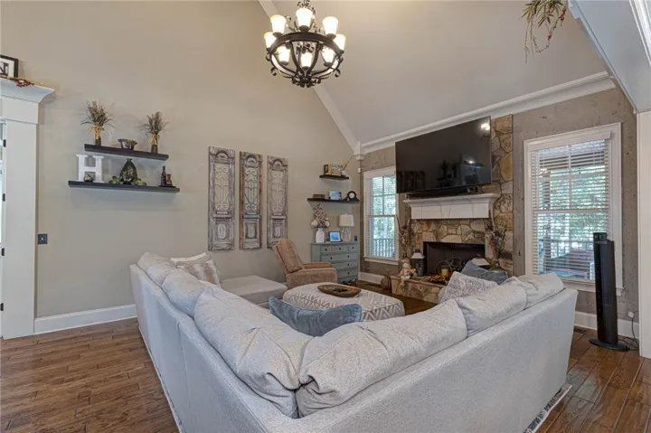 Vaulted ceilings and a stone fireplace create an inviting atmosphere in this main living space.