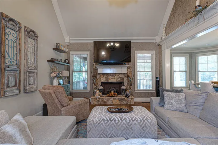 High vaulted ceilings and a classic stone fireplace define this inviting living space.
