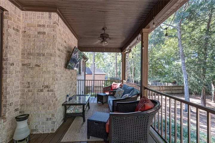 Rich wood plank ceilings and brick accents frame this serene elevated back porch.