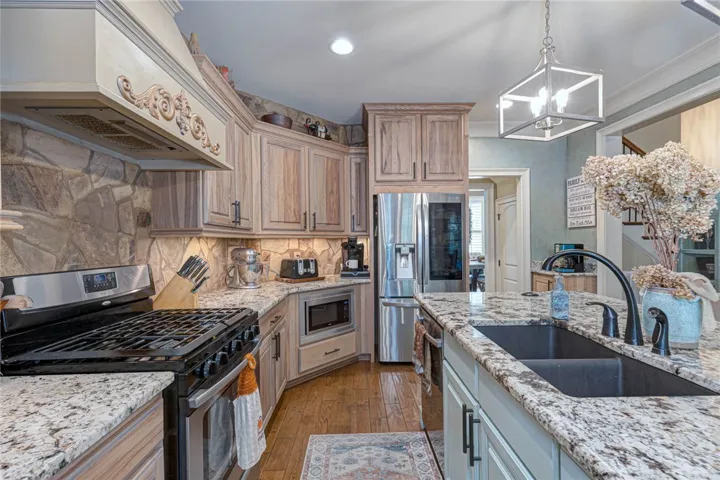 Rich wood cabinetry and stone accents complement granite countertops in this functional workspace.