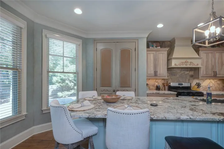 Polished granite countertops and classic crown molding elevate this bright kitchen space.
