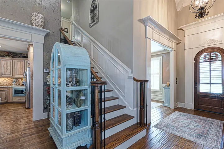 Rich hardwood flooring and classic millwork define this grand double-height entrance foyer.
