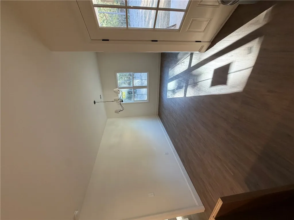 Natural light streams across rich wood-inspired flooring in this versatile dining area.
