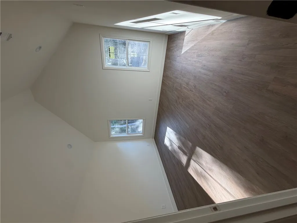 Angled ceilings and wood-style flooring define this versatile interior space.
