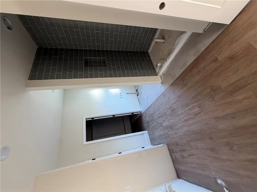 A tiled walk-in shower highlights the evolving design of this primary bathroom.