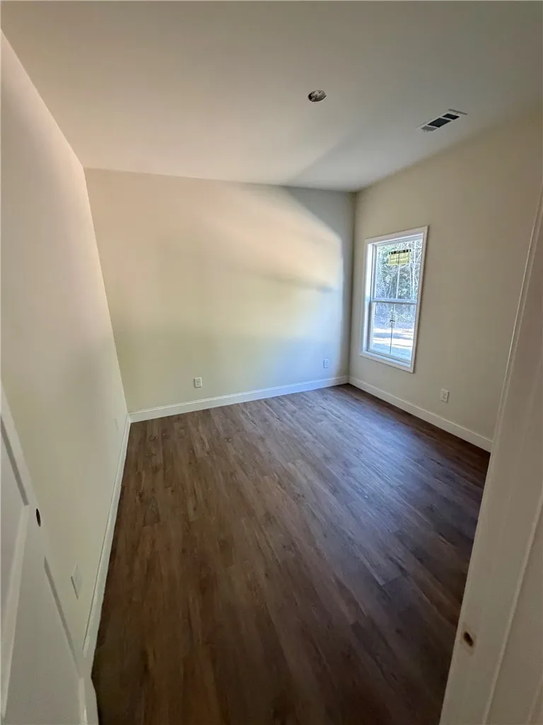A window bathes this room in natural light, showcasing the wood-look flooring and crisp trim.