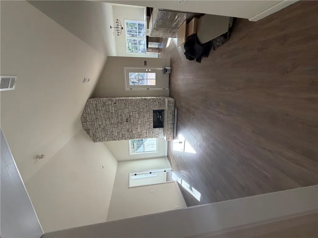An impressive stone fireplace anchors the vaulted living space, complete with durable wood-look flooring.