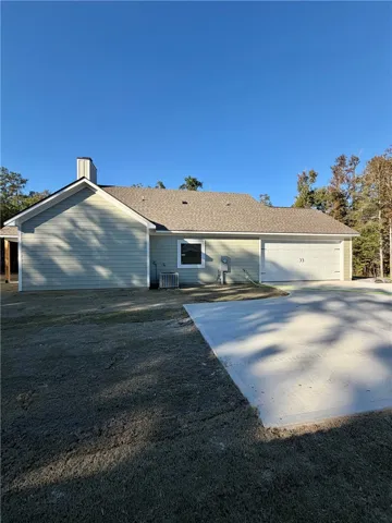 Clean architectural lines define this modern exterior featuring a concrete driveway and spacious garage.
