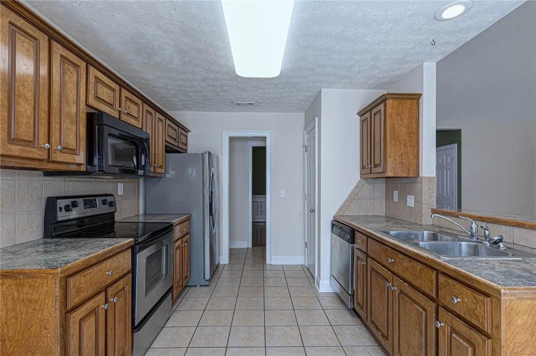 Warm wood cabinetry and tile flooring define this functional galley kitchen layout.