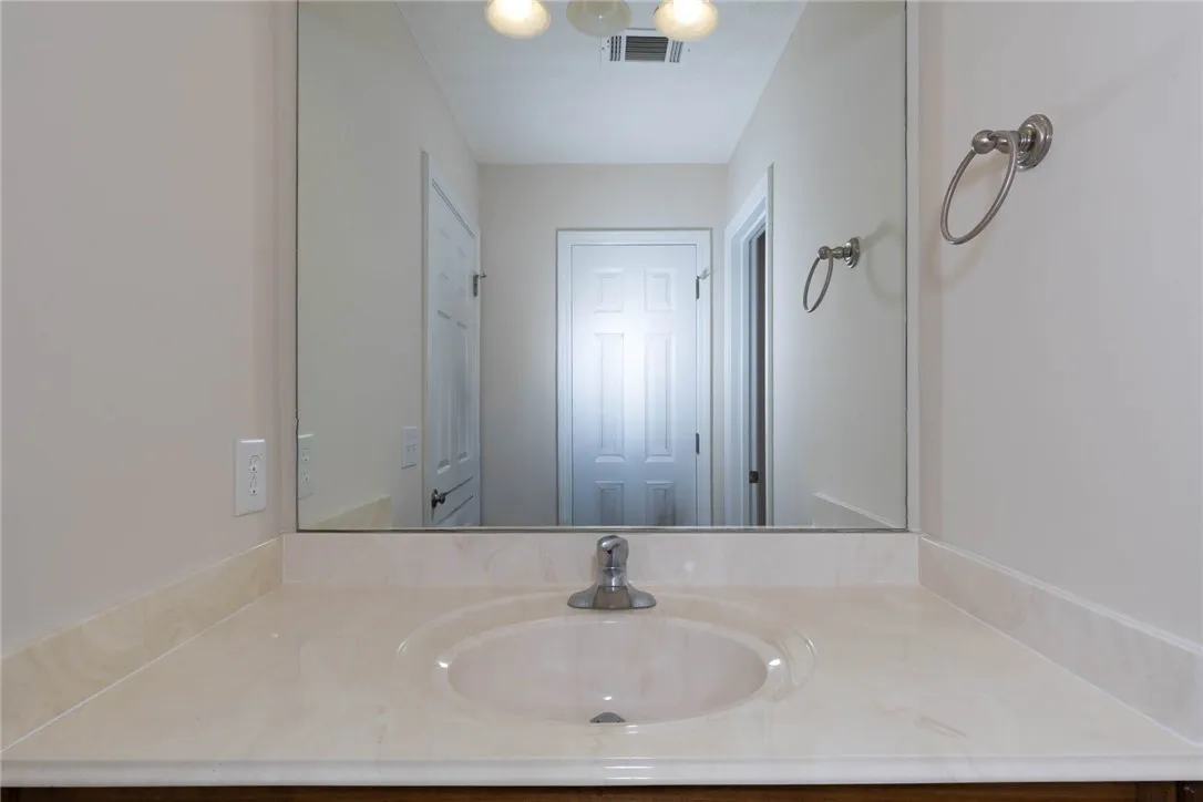 Clean lines and classic solid surface countertops define this well-appointed washroom space.