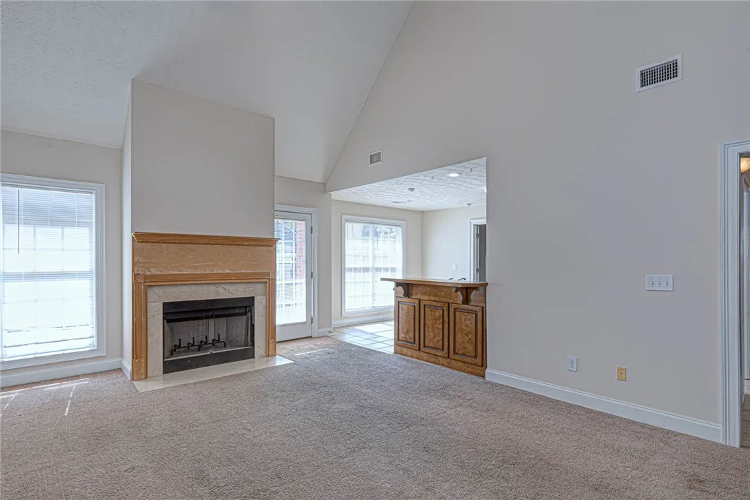 Dramatic vaulted ceilings and a classic fireplace anchor this open and inviting living space.