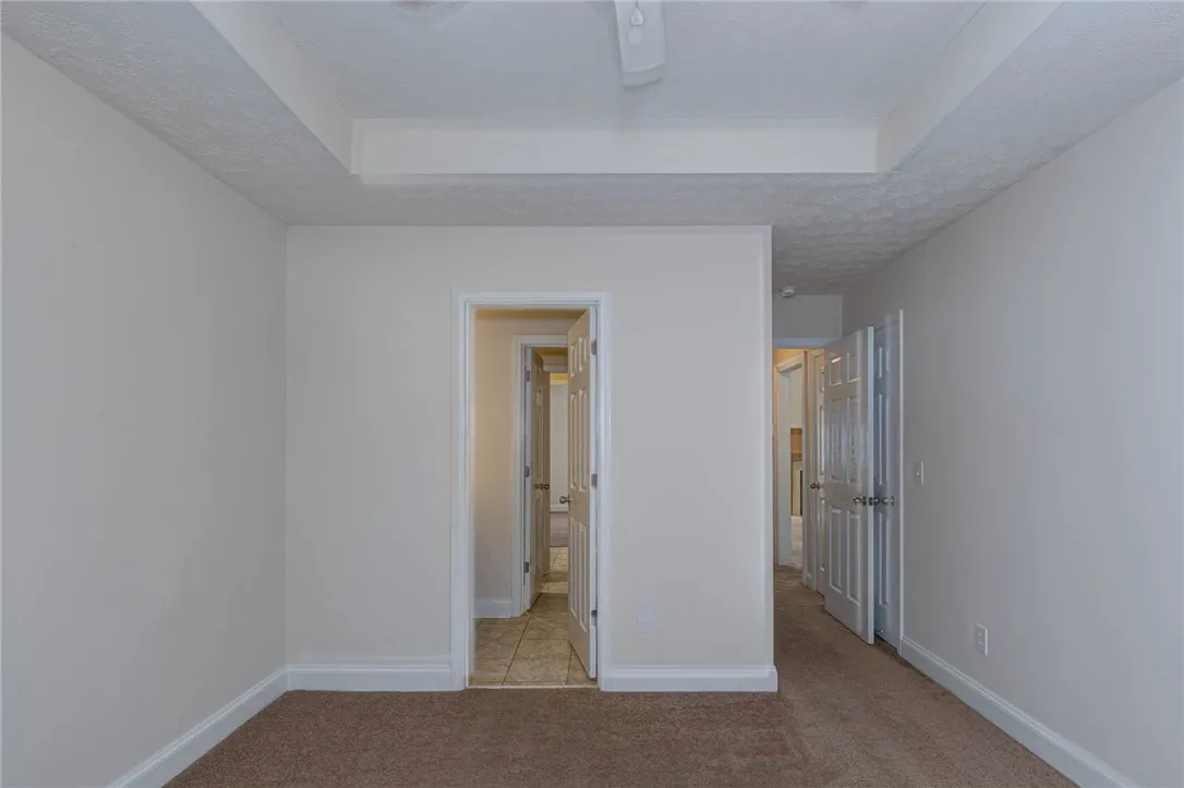Soft carpeting and a classic tray ceiling detail a versatile interior space.