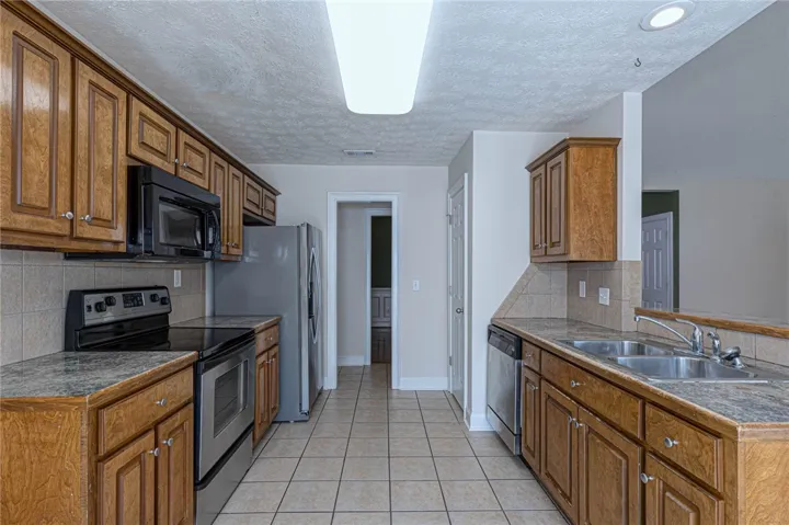 Warm wood cabinetry and tile flooring define this functional galley kitchen layout.