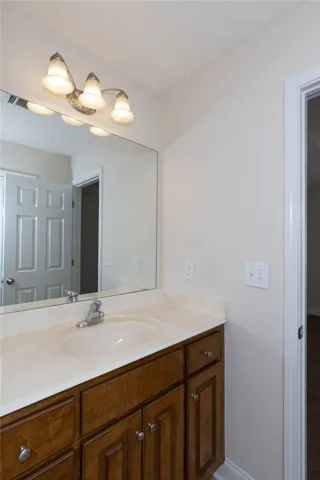 A classic wood vanity and large mirror anchor this functional bathroom space.