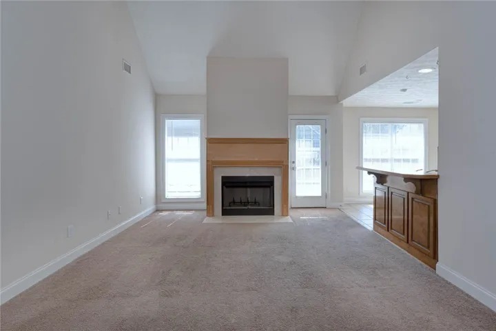 Vaulted ceilings and a central fireplace anchor this inviting open living space.