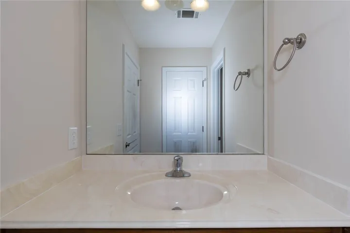 Clean lines and classic solid surface countertops define this well-appointed washroom space.