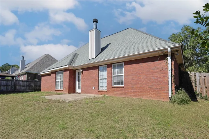 Classical brick architecture accents this exterior, complete with a private yard and paved patio space.
