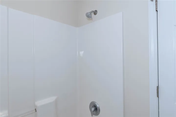 Clean white surround paneling lines this functional shower stall.