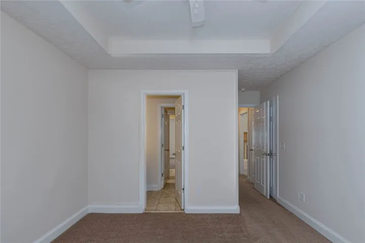 Soft carpeting and a classic tray ceiling detail a versatile interior space.