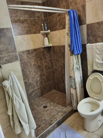 Richly tiled walk-in shower accents this functional bathroom space.