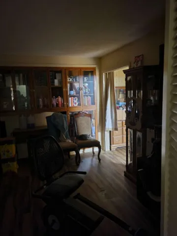 A versatile interior room with warm wood flooring and built-in shelving showcases classic architecture.