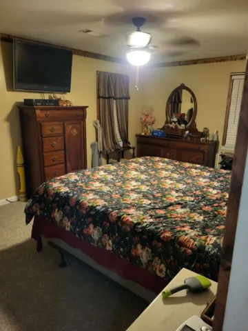 Crown molding frames this cozy bedroom, complete with soft carpeting and natural light.