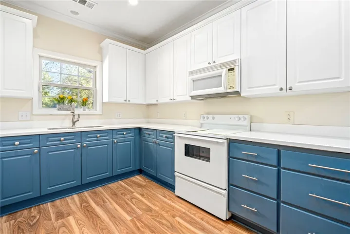 Gleaming hardwood floors complement the custom dual-tone cabinetry in this beautifully designed kitchen.