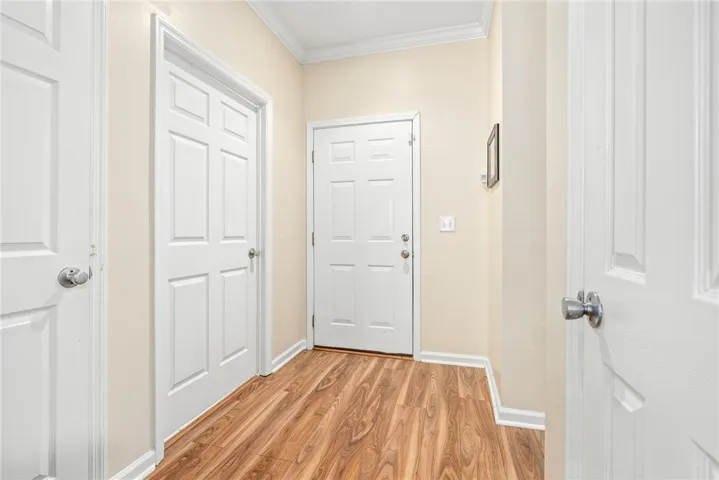 Rich wood-toned flooring and classic crown molding accent this welcoming home entrance.
