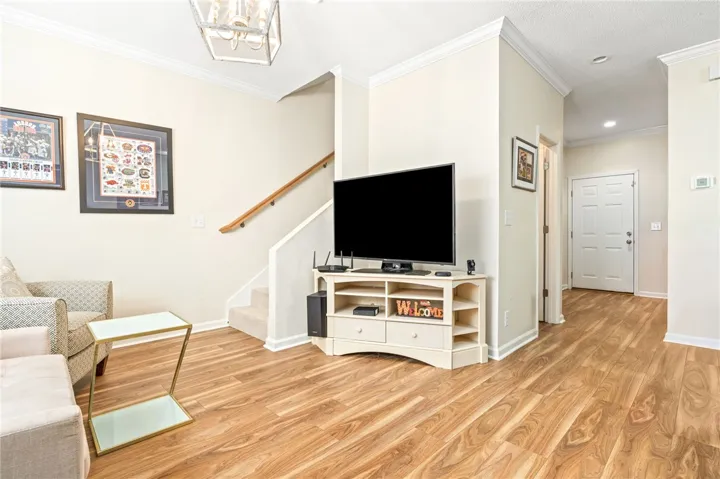 Rich wood-patterned flooring and crisp crown molding flow throughout the open main level.