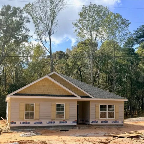 Nestled among mature trees, this newly constructed residence showcases charming shingle accent gables and decorative shutters.