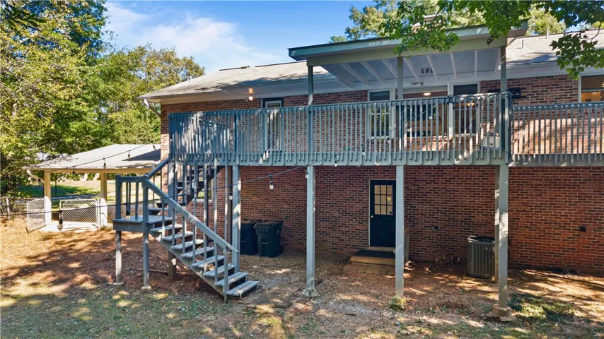 A spacious elevated wooden deck spans the back of this classic brick home.