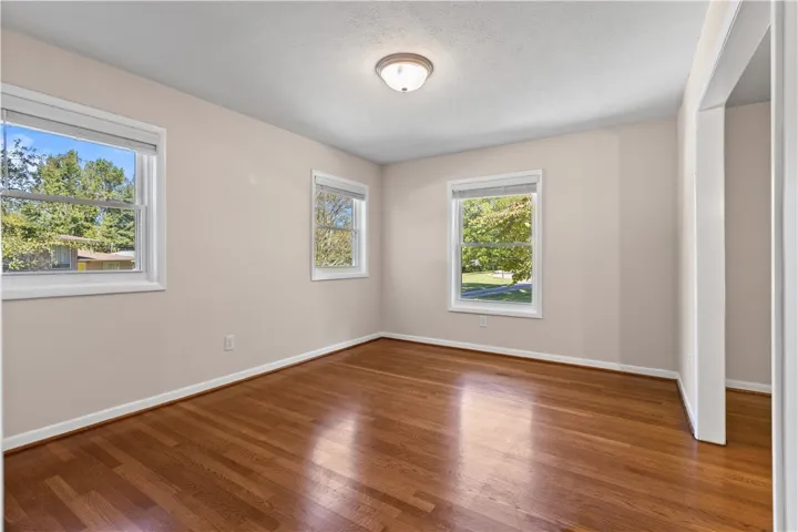 Rich hardwood flooring complements the neat molding and multiple windows in this serene space.