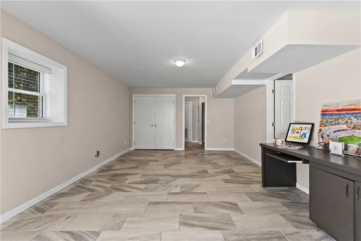 Textured tile flooring runs throughout this versatile garden-level room.