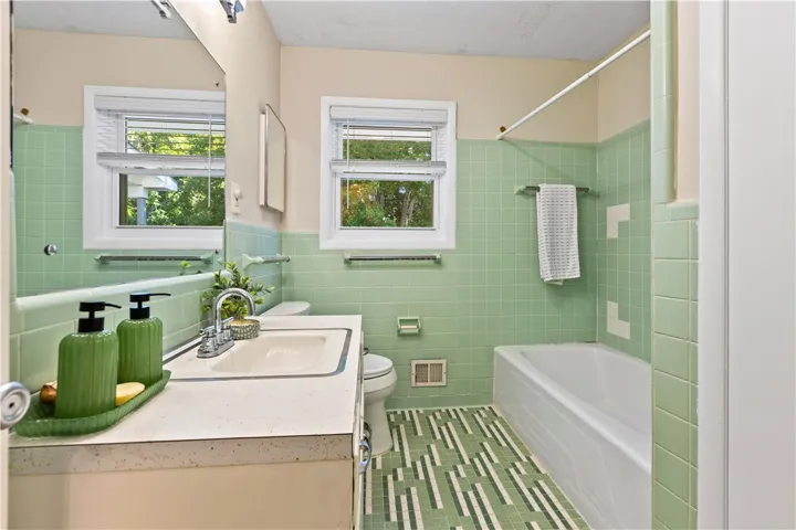 Retro tile surrounds the tub and matching vanity in this classic full bathroom.